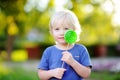 Cute toddler boy with big green lollipop Royalty Free Stock Photo