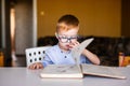 Cute toddler boy with down syndrome with big glasses reading intesting book Royalty Free Stock Photo