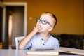 Cute toddler boy with down syndrome with big glasses reading intesting book