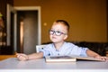 Cute toddler boy with down syndrome with big glasses reading intesting book