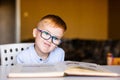 Cute toddler boy with down syndrome with big glasses reading intesting book