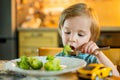 Cute toddler boy eating broccoli. First solid foods. Fresh organic vegetables for infants. Healthy nutrition for the family Royalty Free Stock Photo