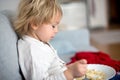 Cute toddler boy, eating pasta with white cheese at home Royalty Free Stock Photo