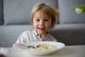 Cute toddler boy, eating pasta with white cheese at home Royalty Free Stock Photo