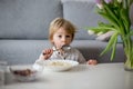 Cute toddler boy, eating pasta with white cheese at home Royalty Free Stock Photo
