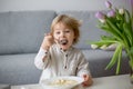 Cute toddler boy, eating pasta with white cheese at home Royalty Free Stock Photo