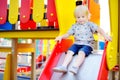 Cute toddler boy having fun on slide on playground Royalty Free Stock Photo