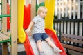 Cute toddler boy having fun on slide on playground. Active outdoors games for little children Royalty Free Stock Photo