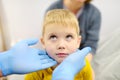 A cute toddler boy with his mother are at an appointment with a pediatrician. The doctor ENT is examines lymph nodes of a little Royalty Free Stock Photo