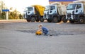 Cute toddler boy interestedly plays with toy dump truck on control panel sitting on asphalt Royalty Free Stock Photo