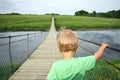 Cute toddler boy overcoming fear, prepering to crossing suspension bridge. Face your fears, look into the future, opening a new w