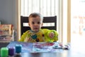 Cute toddler boy painting at the kitchen table Royalty Free Stock Photo