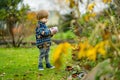 Cute toddler boy picking fresh berries on organic raspberry farm on warm autumn day. Harvesting fresh berries on fall day Royalty Free Stock Photo