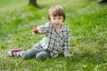 Cute toddler boy playing in blooming cherry tree garden on beautiful spring day. Adorable baby having fun outdoors Royalty Free Stock Photo