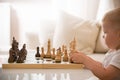 Cute toddler boy playing chess in the room. Little clever child playing chess at home. Education concept. Preschooler with chess Royalty Free Stock Photo