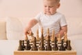 Cute toddler boy playing chess in the room. Little clever child playing chess at home. Education concept. Preschooler with chess Royalty Free Stock Photo