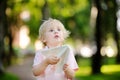 Cute toddler boy playing with paper plane in a summer park Royalty Free Stock Photo