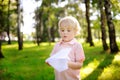 Cute toddler boy playing with paper plane in a summer park Royalty Free Stock Photo