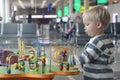 Cute toddler boy playing in public play room in airport terminal while waiting his airplane. Travel with child, family vacation Royalty Free Stock Photo