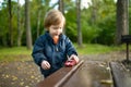 Cute toddler boy playing with red toy car outdoors. Kid exploring nature. Small child having fun with toys. Autumn activities for Royalty Free Stock Photo