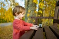 Cute toddler boy playing with red toy car outdoors. Kid exploring nature. Small child having fun with toys Royalty Free Stock Photo