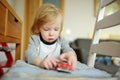 Cute toddler boy playing with red toy car. Small child having fun with toys. Kid spending time in a cozy living room at home Royalty Free Stock Photo