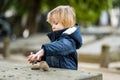 Cute toddler boy playing with rocks and pebbles in Bergamo. Little child having fun exploring in Citta Alta, upper district of Royalty Free Stock Photo