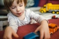 Cute toddler boy playing with toy cars. Small child having fun with toys. Kid spending time in a cozy living room at home Royalty Free Stock Photo