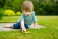 Cute toddler boy playing with yellow toy car outdoors. Kid exploring nature. Small child having fun with toys Royalty Free Stock Photo