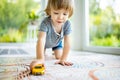 Cute toddler boy playing with yellow toy car. Small child having fun with toys. Kid spending time in a cozy living room at home Royalty Free Stock Photo