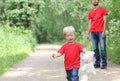 Cute toddler boy with a teddy bear in his arms is crying. Dad is standing behind. Parenting difficulties concept. Family look clot Royalty Free Stock Photo