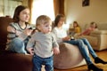 Cute toddler boy watching a group of preteen kids playing video games at home Royalty Free Stock Photo