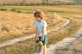 Cute toddler boy working on farm outdoors. Child farmer in the farm with harvest at countryside background. Crop