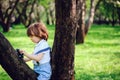 Cute toddler child boy with long hair in stylish outfit playing with toy car on the walk in summer Royalty Free Stock Photo