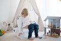 Cute toddler child, boy, sitting on a baby toilet potty, playing