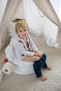 Cute toddler child, boy, sitting on a baby toilet potty, playing