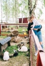 Cute toddler child girl and her mother looking on rabits sitting in cage at the zoo or animal farm Royalty Free Stock Photo