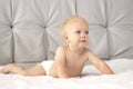 CUte toddler in a diaper lying on the white blanket against the grey background. Copy space Royalty Free Stock Photo