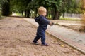 Cute toddler with a drawn rapier. Funny baby boy in the park with a pictured epee