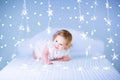 Cute toddler girl with curly hair between Christmas lights Royalty Free Stock Photo