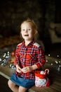 Cute toddler girl eating chocolate egg sitting in a hunting house decorated for Christmas. The concept of a Christmas morning. Royalty Free Stock Photo