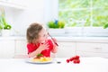 Cute toddler girl eating spaghetti in a white kitchen Royalty Free Stock Photo