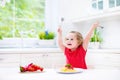 Cute toddler girl eating spaghetti in a white kitchen Royalty Free Stock Photo