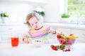 Cute toddler girl having breakfast drinking juice Royalty Free Stock Photo