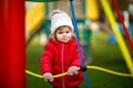 Cute toddler girl having fun on playground. Happy healthy little child climbing, swinging and sliding on different Royalty Free Stock Photo