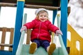 Cute toddler girl having fun on playground. Happy healthy little child climbing, swinging and sliding on different Royalty Free Stock Photo