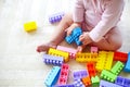 Cute toddler girl having fun with toy blocks sitting on the carp Royalty Free Stock Photo