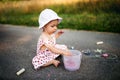 Cute toddler girl outdoors in countryside, chalk drawing on road. Royalty Free Stock Photo