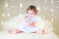 Cute toddler girl playing with her toy bear between soft lights in star shape Royalty Free Stock Photo