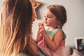 Cute toddler girl playing with mother at home